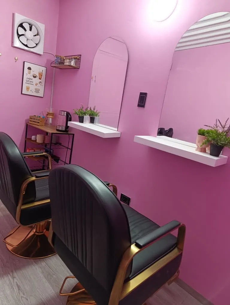 Sillones de peluquería negros con detalles dorados y espejos de arco